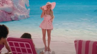 Margot Robbie waving in a pink mini dress in Barbie.