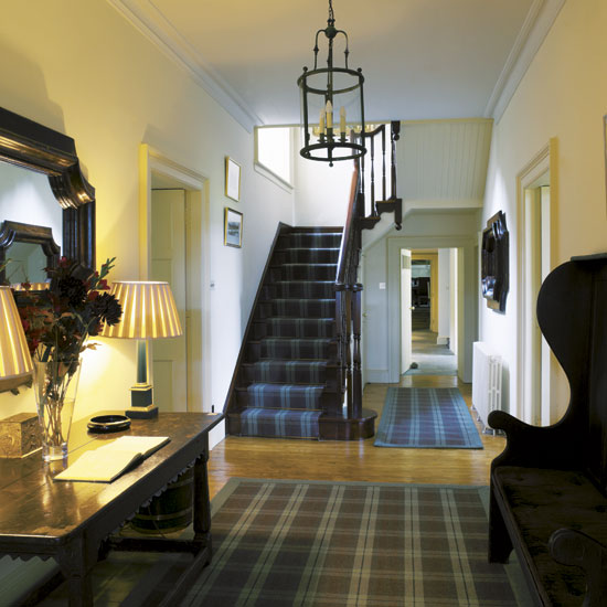 hallway with white wall staircase wooden flooring and carpet