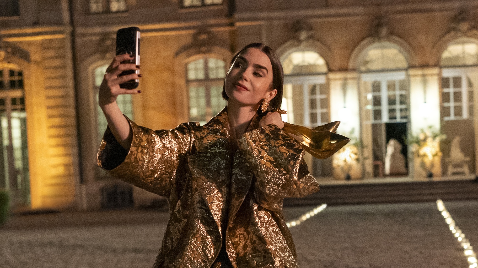 Emily taking a selfie on the street in Emily in Paris Season 6