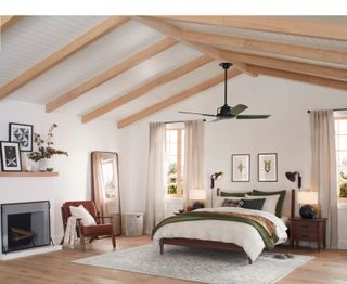 A bedroom with neutral walls, a vaulted ceiling, and wooden beams