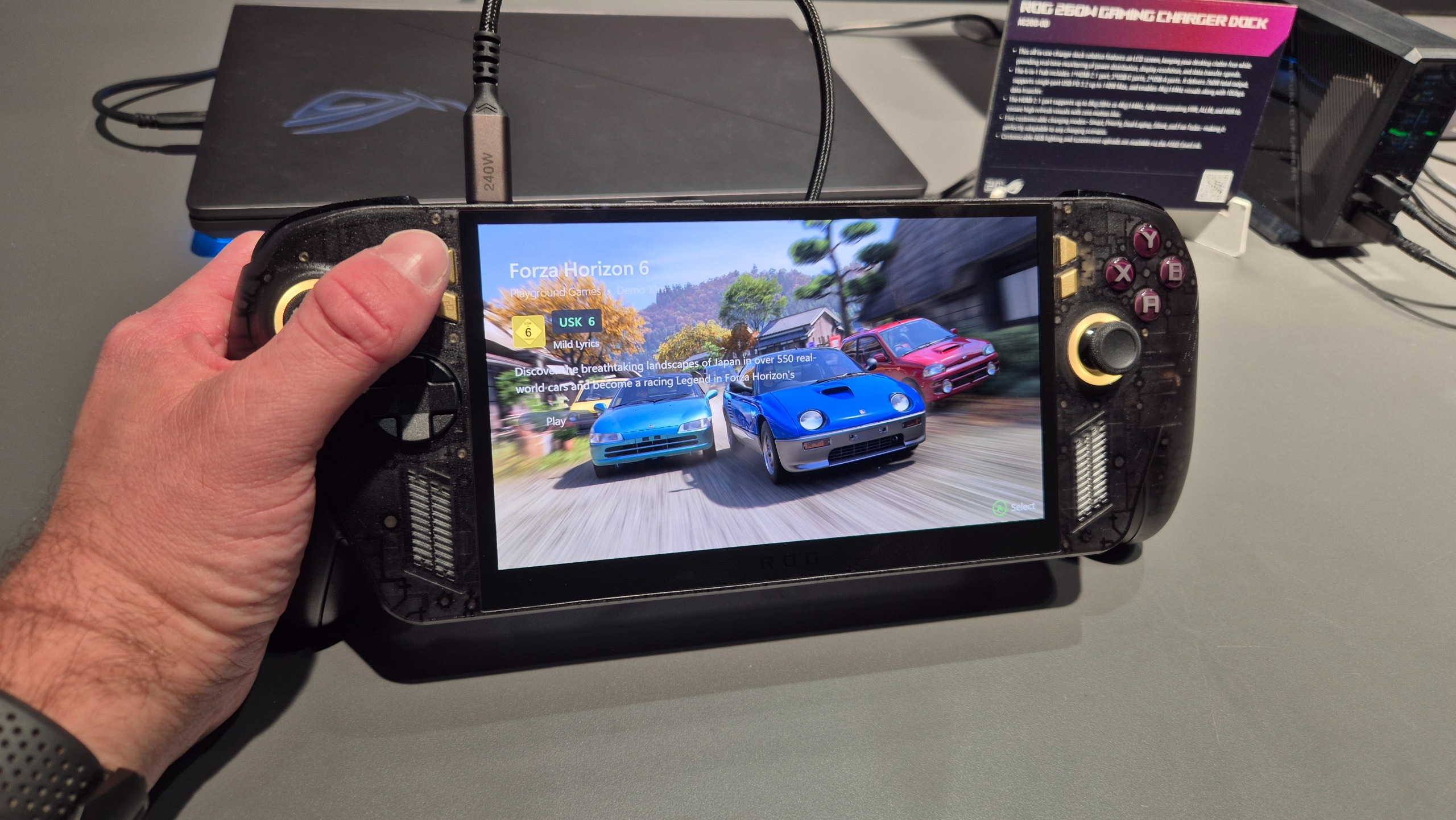 The Asus ROG Xbox Ally X20 handheld being held in one hand by a man and with Forza Horizon 5 on the screen.