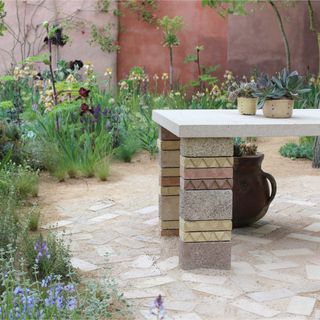 Close up of the plants and stoneware table in RHS Chelsea's The Mediterranean Garden