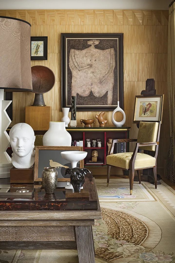 A series of modernly decorated rooms and exterior spaces features organic shaded decor, impressive sculptures, and art.