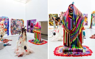 LEFT: Art gallery with white walls, ceiling and grey flooring featuring colourful wall canvases and grotesque sculptures; RIGHT: colourful grotesque masqurade-like sculpture with wcolourful wall canvases behind