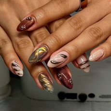 a manicure featuring brown and gold nail polish and 3D gel