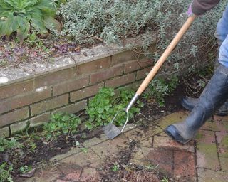 Removing weeds and debris from a patio using a hoe