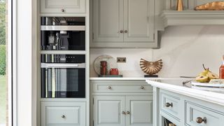 Bank of Miele ovens in pale blue kitchen