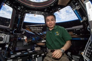 Expedition 39's Koichi Wakata about to read "Max Goes to the Space Station" (Big Kid Science, 2013) by Jeffrey Bennett, which was translated in Japanese.