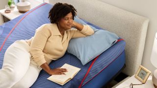 A woman laying on a Sealy Posturepedic bed