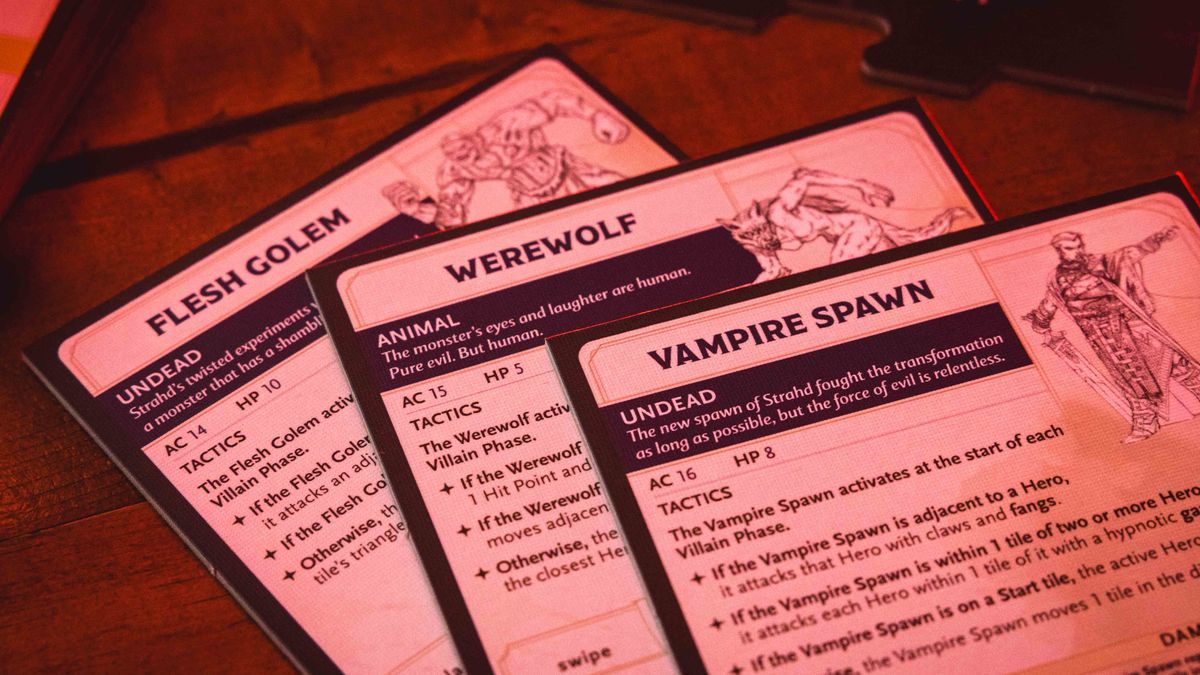 Castle Ravenloft board game components laid out on a dark table, with an ominous red glow on them