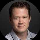 Headshot of a clean shaven man in a striped shirt