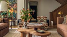 Modern living room with statement artwork curved wooden coffee table and brown sofas