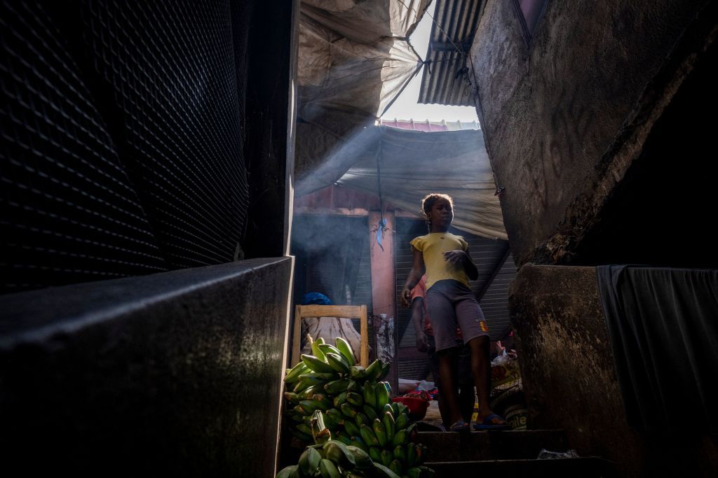 A girl walks around a market in Haiti.