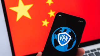 VPN on phone screen, with Chinese flag displayed on laptop in background