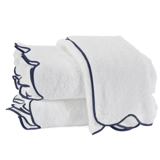 folded white towels with a thin navy scalloped trim all round