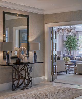 creamy hallway with designer console, mirror and lamps