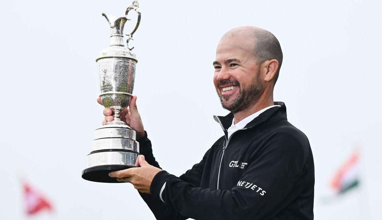 Brian Harman holds the Claret Jug a loft 