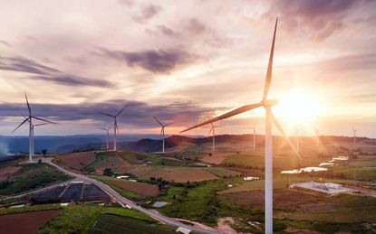 A lone windmill sits on a grassy plain