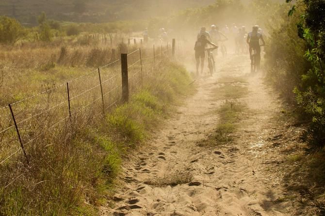 Racers walk through thick sand