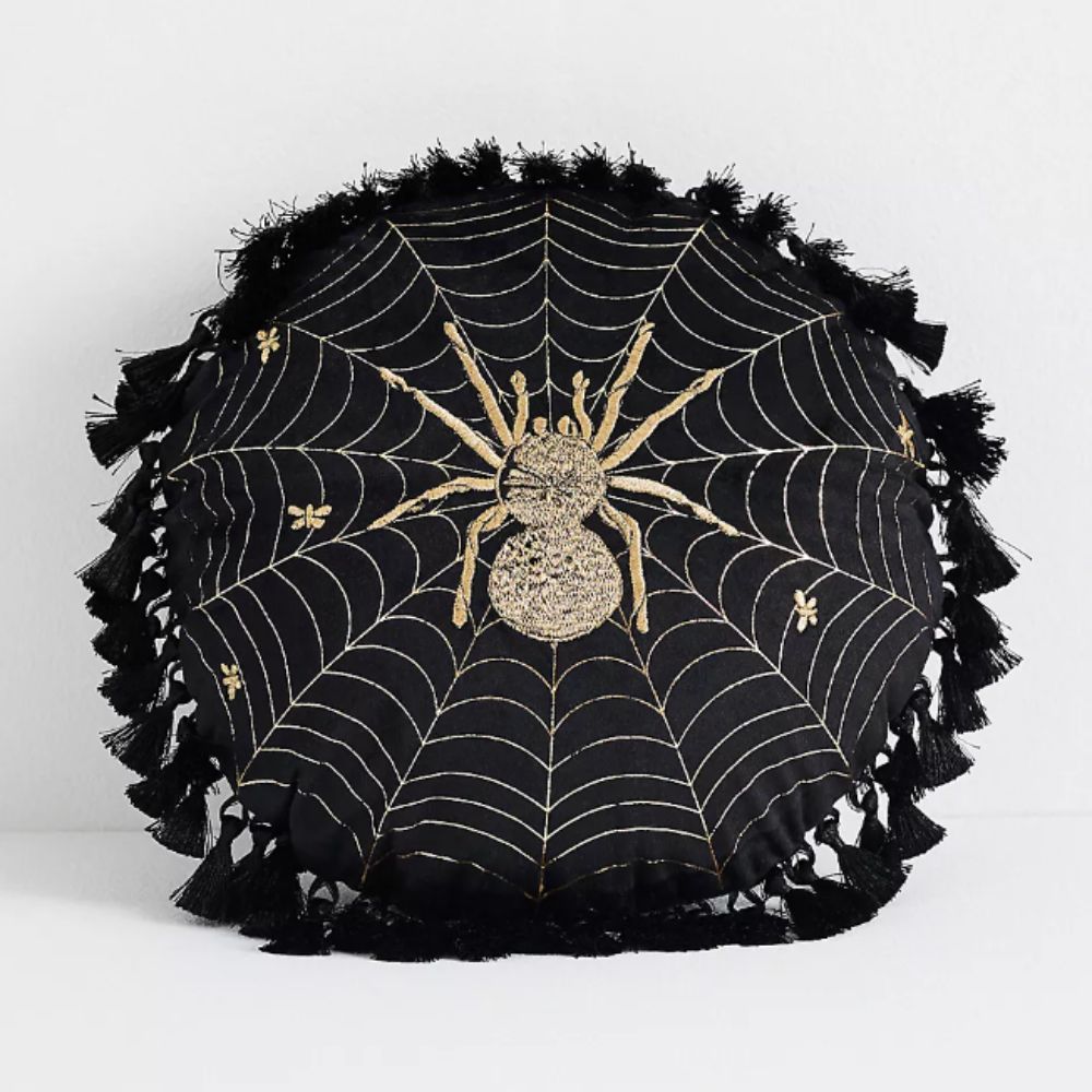 Round black cushion with a spider motif on the front