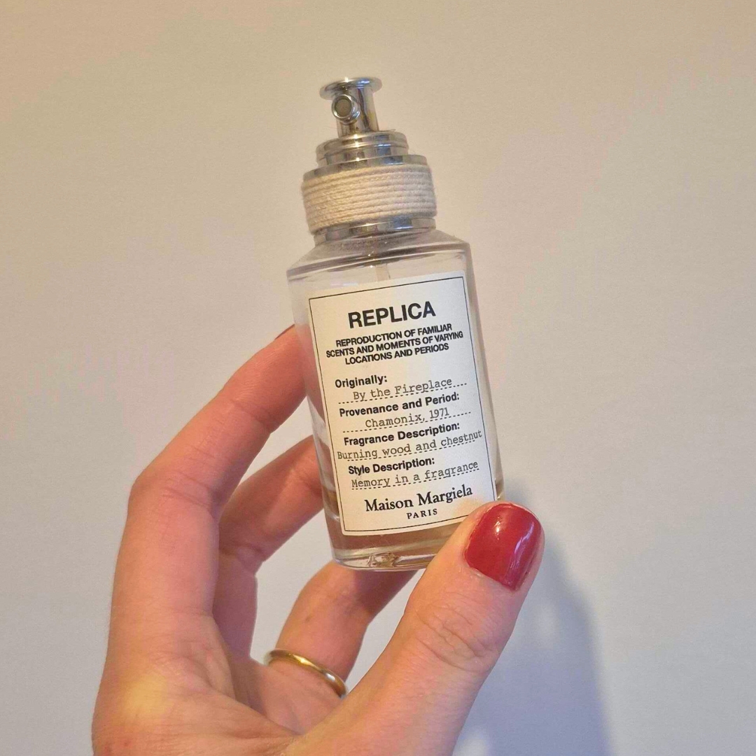 Hand holding empty bottle of Maison Margiela By the Fireplace Eau De Toilette