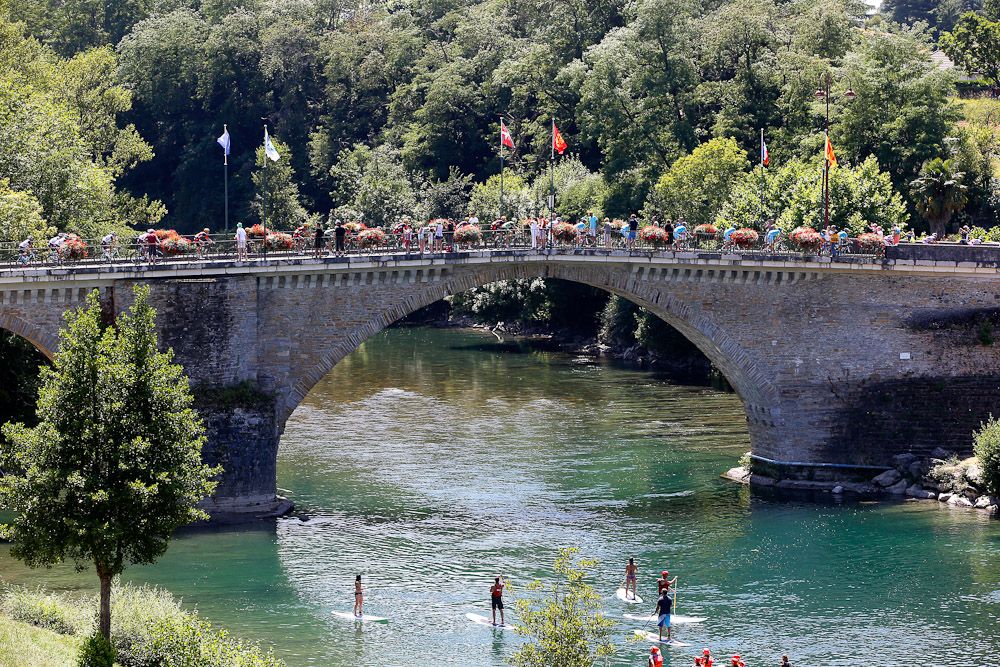 The peloton crosses a bridge during stage 10.