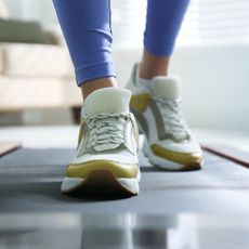 A woman walking on a treadmill in her living room