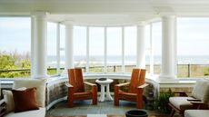 Porch with columns, tiled floor and wooden adirondack chairs