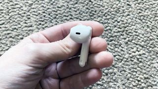 one oppo enco air earbud held in someone's hand