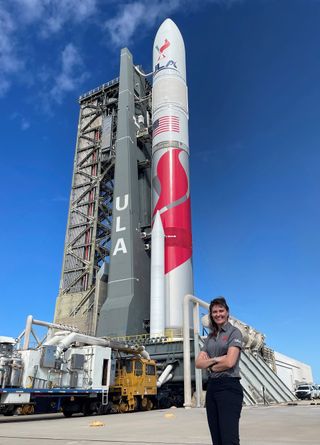 United Launch Alliance senior graphic designer Cory Wood poses with the company's first Vulcan rocket, the focus of the comic book she illustrated, 