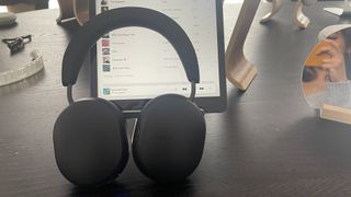 Sonos Ace headphones in black finish with iPad on desk