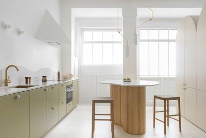 modern kitchen with curved island and white triangular hood