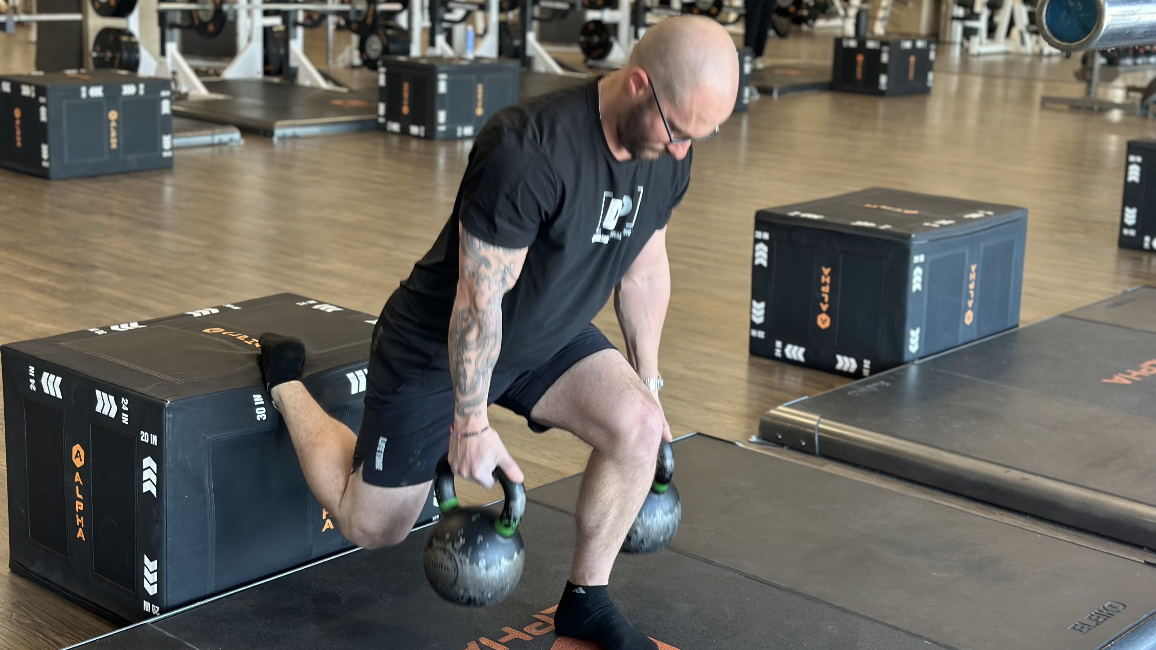 personal trainer Miller Latvala demonstrates a Bulgarian split squat with two kettlebells