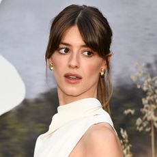 Daisy Edgar-Jones looks away from the camera wearing a white halter dress