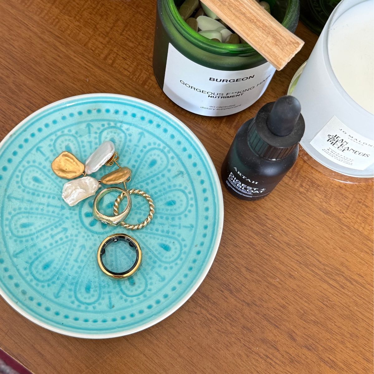 Health writer Anna Bartter's Oura ring review: A shot of the Oura fitness tracker ring on her hand, during her workout, and on her dresser 