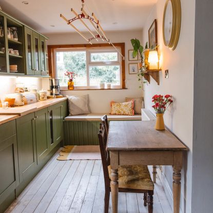 Green country kitchen makeover with shaker cupboards and farmhouse table.