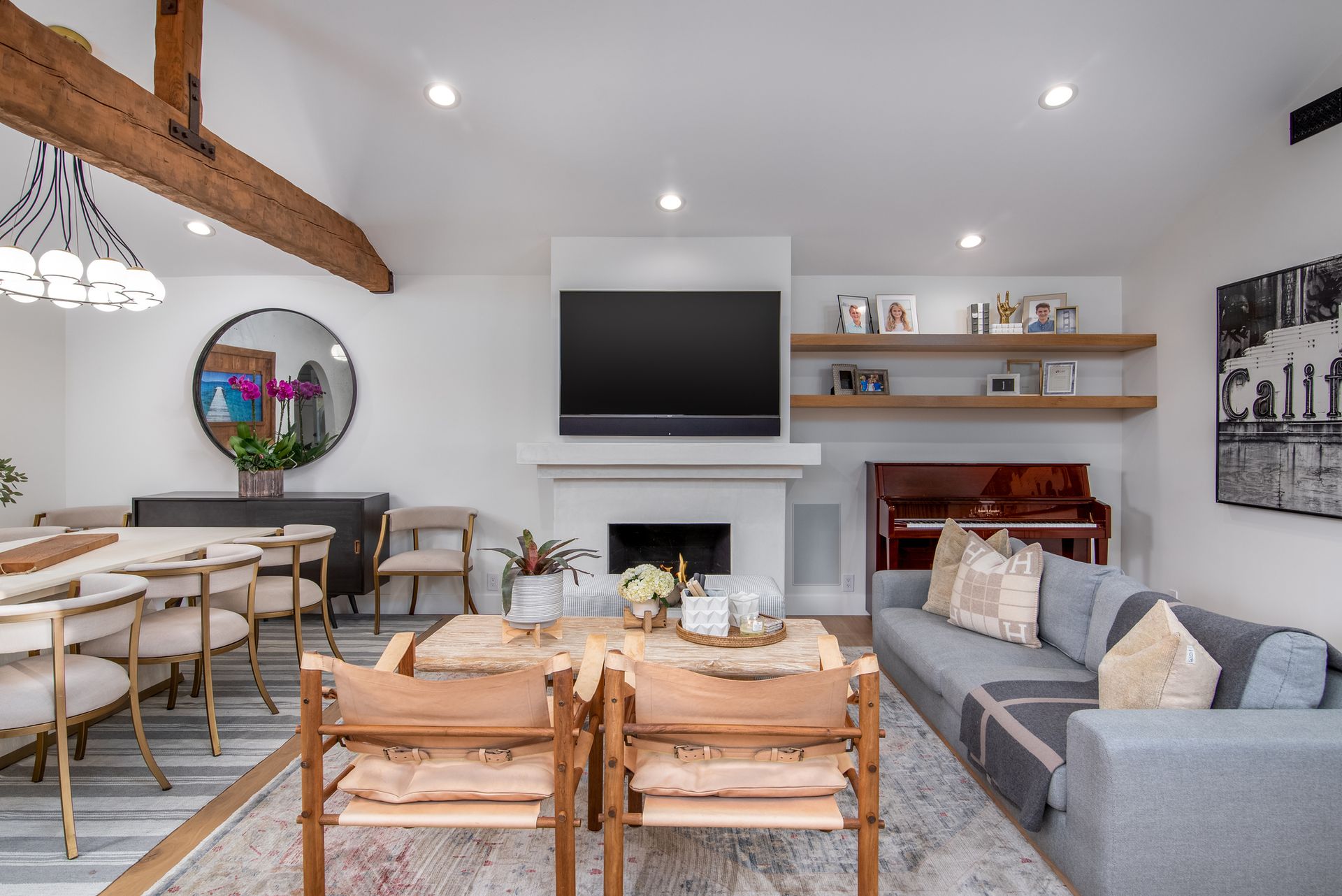 An open plan living room with a neutral palette, chairs around a coffee table, and a dining table