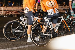 Hunt Limitless UD Carbon Spokes wheels on white crit bikes with riders in orange jerseys