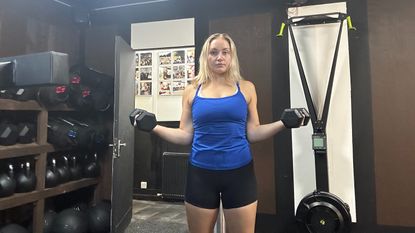 Fitness writer Alice Porter doing a dumbbell shoulder rotation exercise in gym