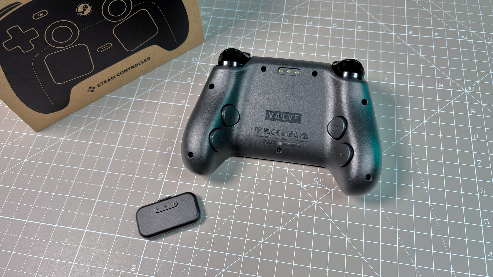 The Steam Controller on a desk during a teardown, with various parts removed.