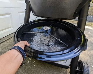 cleaning out the ash from a kamado grill