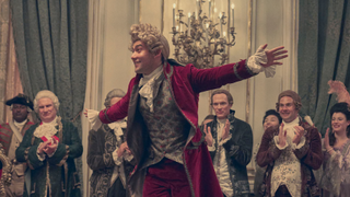 Wolfgang "Amadeus" Mozart (played by Will Sharpe) entertains the court. Antonio Salieri (Paul Bettany) watches on