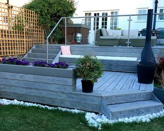 A backyard with 2.4m Heritage Composite Decking, stairs and garden furniture decor