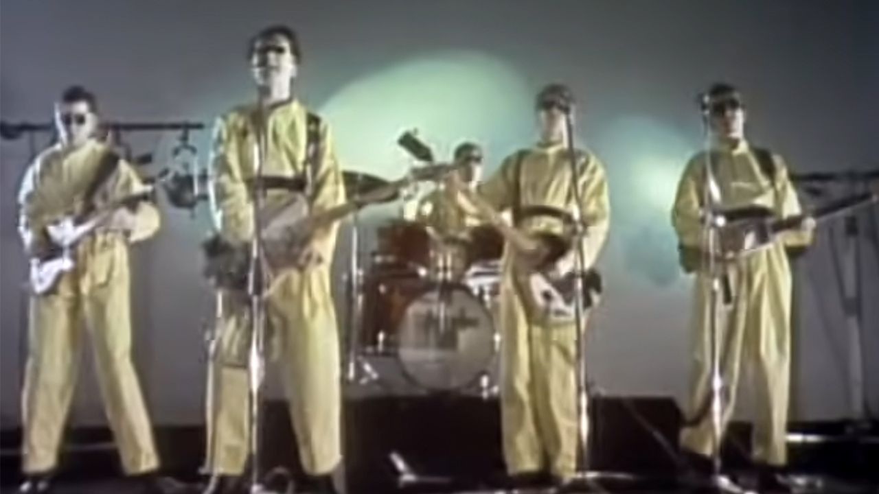 Devo in yellow hazmat suits performing in the 