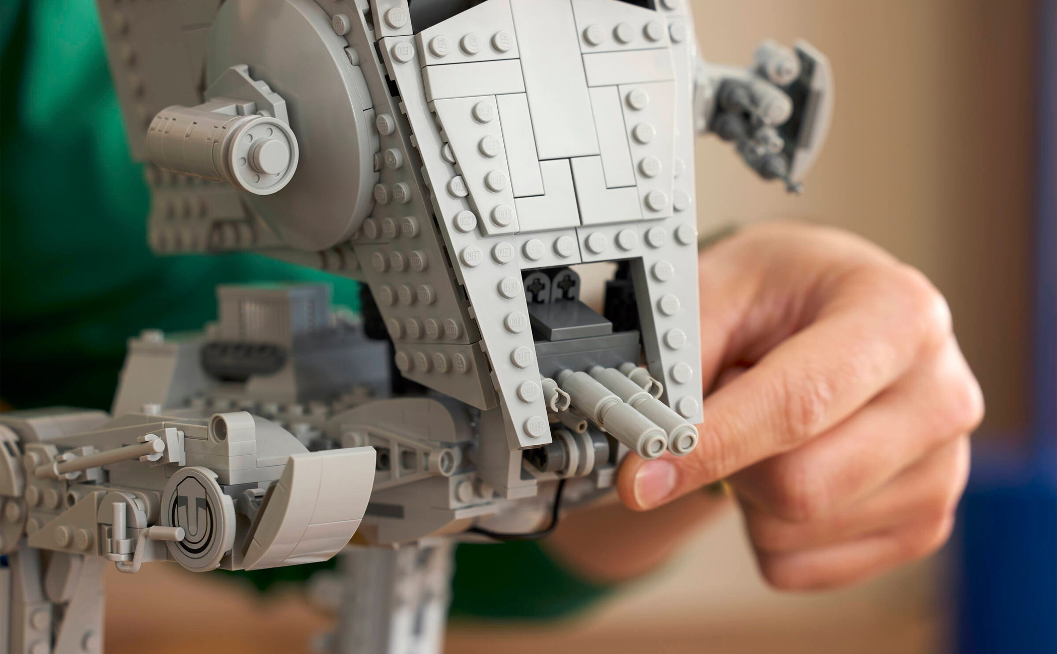 A close up of a Lego Star Wars AT-ST Walker 75417 set, with a hand moving the front guns.