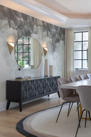 A dining room with mural and lit wall sconces