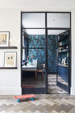 Closet office with glass partition and blue wallpaper