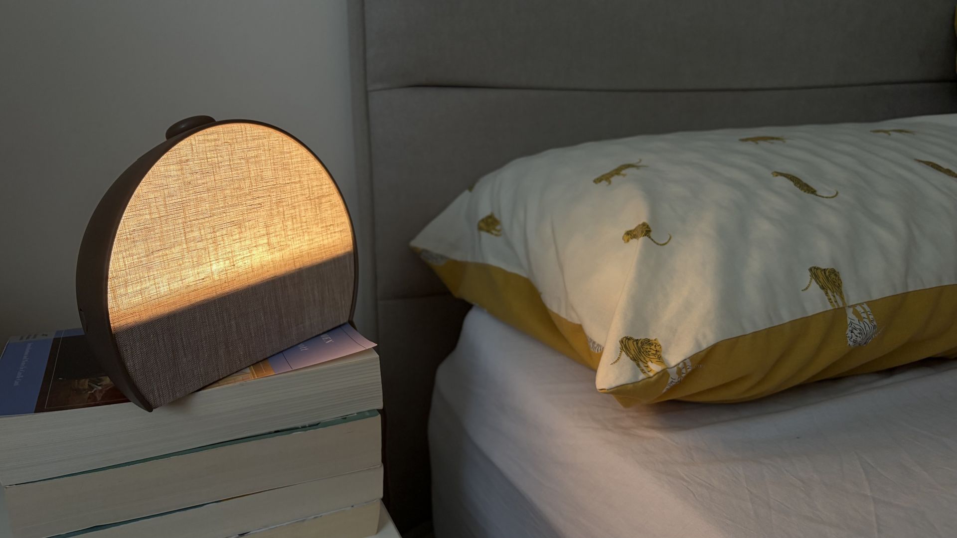 The new Hatch Sleep Clock on a white wooden nightstand in our reviewer's bedroom