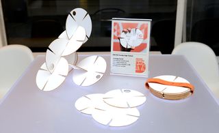 Interlocking white circular cards that can be arranged into a sculpture or mobile