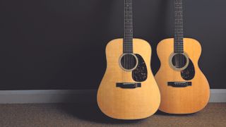 Martin D-18 and 00-21 leaning against a dark grey wall 